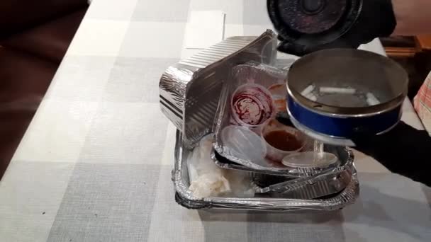 一位老年妇女吃完饭后清扫桌子 黑眼圈的手把送来的午餐剩下的盒子堆起来 包装纸被放在不同的垃圾箱中循环利用 — 图库视频影像