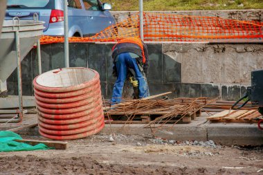 Dnipropetrovsk, Ukrayna - 11,30,2021: Kentsel alanlara kanalizasyon boruları döşeme çalışmaları. Traktör ve kazı çalışması.