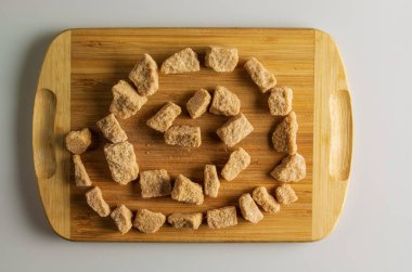 Esmer, işlenmemiş şekerin geçmişi. Sağlıklı gıda konsepti. Tahta kesim tahtası üzerinde kamış şekeri.