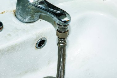 Su sayacı doğrulama işlemi. Esnek bir su hortumu su musluğuna bağlıdır. Su tasarrufu kavramı.