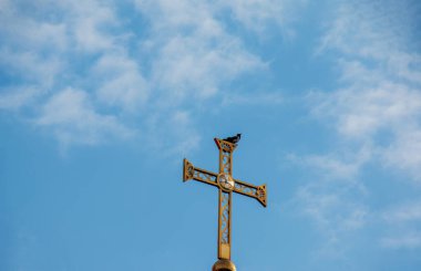 Ortodoks kilisesi mavi gökyüzüne karşı geçiyor. Bir kırlangıç çarmıha gerilir. Paskalya konsepti.