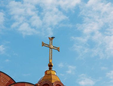 Ortodoks kilisesi mavi gökyüzüne karşı geçiyor. Bir kırlangıç çarmıha gerilir. Paskalya konsepti.