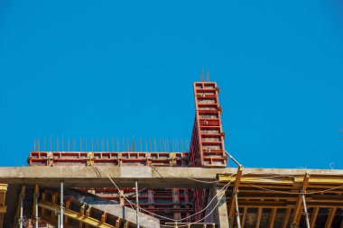 Mavi gökyüzüne karşı konut binalarının yük taşıyıcı yapılarının modern yapımında biçimlendirme ve inşaat metal destekleri kullanılır..