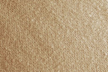 Bej örülmüş halıyı yakından gösteren gerçekçi bir tasvir. Bej arka planda tekstil dokusu. Ayrıntılı sıcak iplik arka planı. Doğal yün kumaş, süveter parçası..