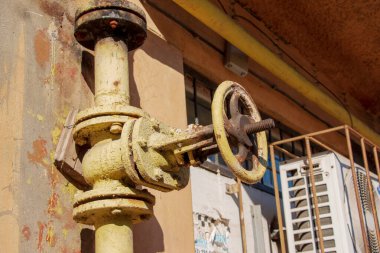 Evin arka planında paslı eski gaz musluğu var..