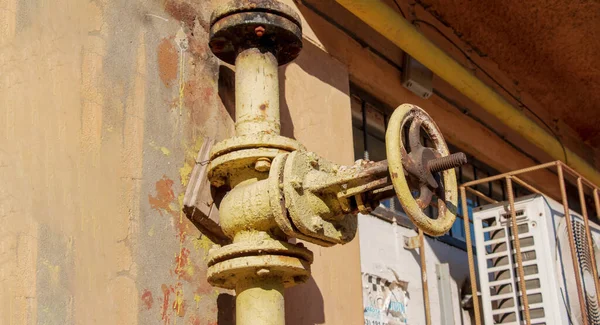 Evin arka planında paslı eski gaz musluğu var..