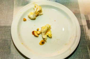 Biyolojik bozunabilir çöp. Limon suyunda kirli peçeteler, beyaz tabakta arta kalan limon kabuğu..