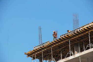 Dnepropetrovsk, Ukraine - 02.09.2022: A worker prepares formwork for a modern metal-concrete structure of a residential building.