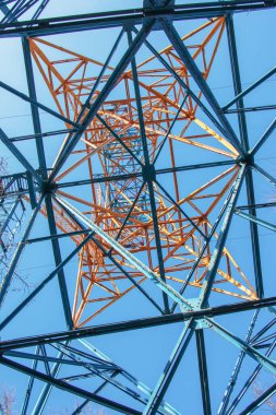 Güzel mavi arkaplanı olan bir elektrik kulesinin yakın görüntüsü. Endüstriyel mühendislik. Yüksek voltajlı elektrik mühendisliği için demir yapı.