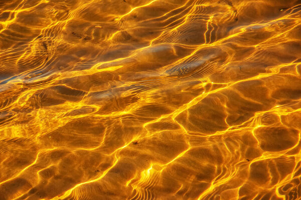 Reflections on the water surface in the river. Background of corrugated pattern of clean water sand. View from above. Abstract background. Shining water. Ripples background wallpaper.