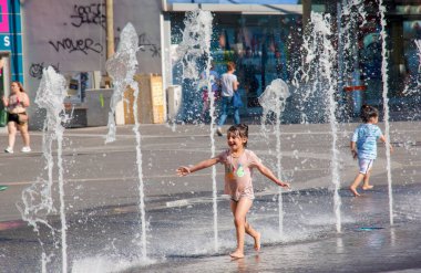 Viyana, Avusturya - 06.13.2022: Çocuklar yaz sıcağında şehir havzasında eğleniyorlar