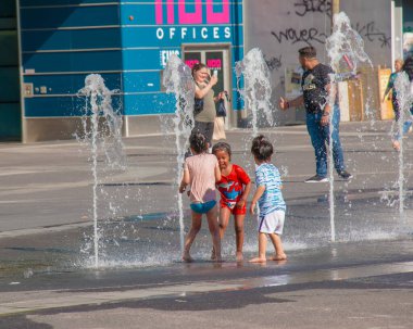 Viyana, Avusturya - 06.13.2022: Çocuklar yaz sıcağında şehir havzasında eğleniyorlar