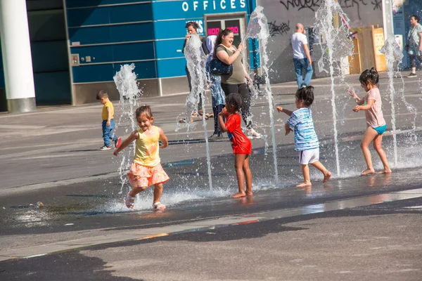 Viyana, Avusturya - 06.13.2022: Çocuklar yaz sıcağında şehir havzasında eğleniyorlar