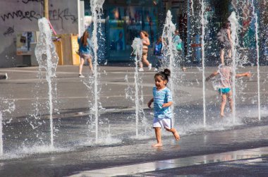 Viyana, Avusturya - 06.13.2022: Çocuklar yaz sıcağında şehir havzasında eğleniyorlar