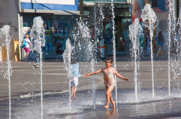 Viyana, Avusturya - 06.13.2022: Çocuklar yaz sıcağında şehir havzasında eğleniyorlar