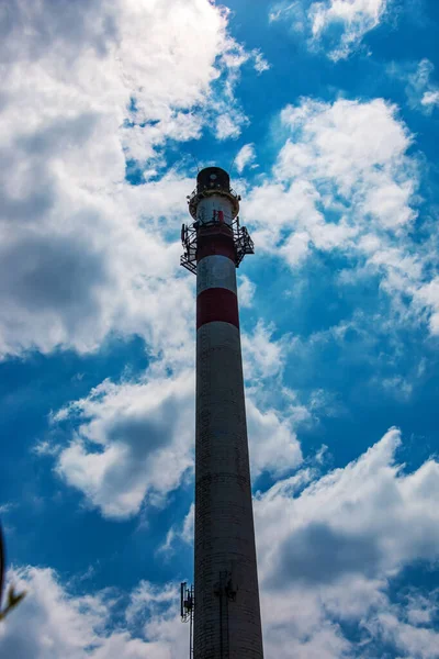 Factory chimney against a cloudy sky. Air pollution from smoke coming out of factory chimneys. The concept of air pollution, environmental problems, atmospheric emissions.