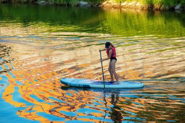 Nitra, Slovakya - 06.15.2022: Genç bir kız Nitra nehri üzerinde bir kanoda yelken açıyor.