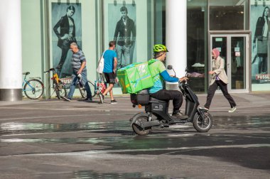 Vienna, Austria - June 13, 2022: Bicycle courier delivering food to a customer.