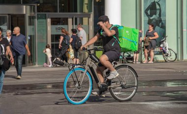 Vienna, Austria - June 13, 2022: Bicycle courier delivering food to a customer.
