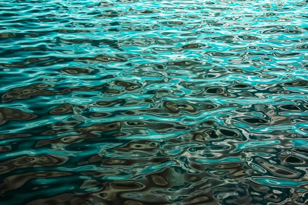 Su dalgalanması dokusu. Gün batımında dalgalı su yüzeyi, suya yansıyan altın ışık..