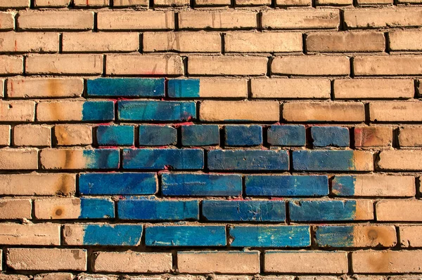 Texture of old colored bricks. Close-up of a red and green brick wall with painted bricks. Horizontal background with free space for text