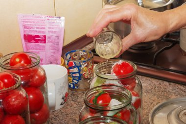 The process of preserving tomatoes for the winter. Ripe red juicy tomatoes in glass jars.