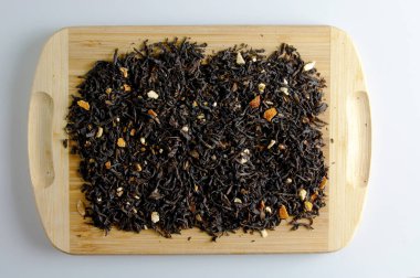 Dry tea based on black with pieces of citrus orange and lemon on a wooden background.