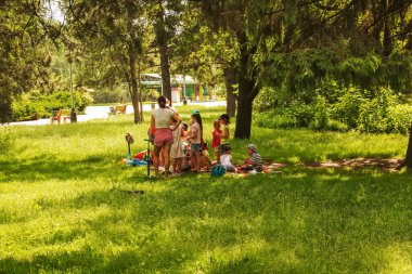 Dnepropetrovsk, Ukrayna - 06.25.2021: Özel bir anaokulundan öğretmenlerle parkta yürüyüş yapan bir grup çocuk.