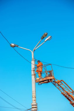 Dnipro, Ukrayna - 02.15.2022: Koruyucu ekipman kullanan bir belediye çalışanı elektrik şebekesindeki kesintiyi ortadan kaldırmak için tehlikeli işler yapıyor.