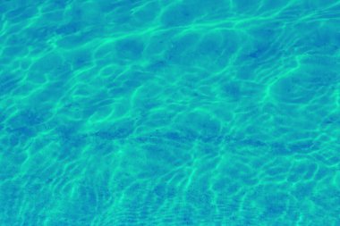 Su dalgalanması dokusu. Dalgalı su yüzeyi. Mavi gökyüzü suya yansıyor.