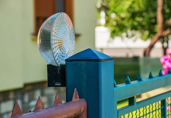 Lighting spotlight on the fence post. Outdoor lighting system.