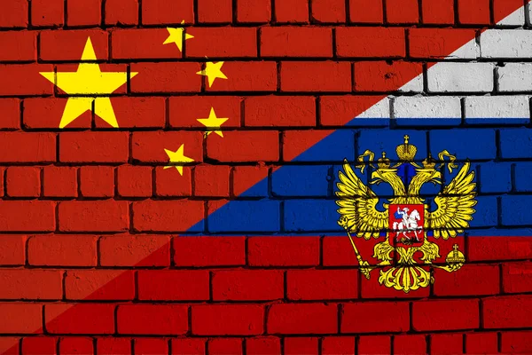 Contact between Russia and the People\'s Republic of China. Concept. Russia and China flag background on brick wall texture.