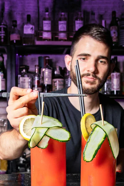 cocktail shaker adding straws to cocktails in a nightclub. vertical