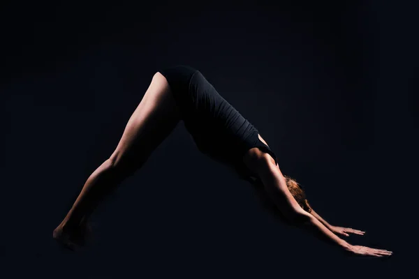 Yoga posture in silhouette on black background in a studio shot. horizontal