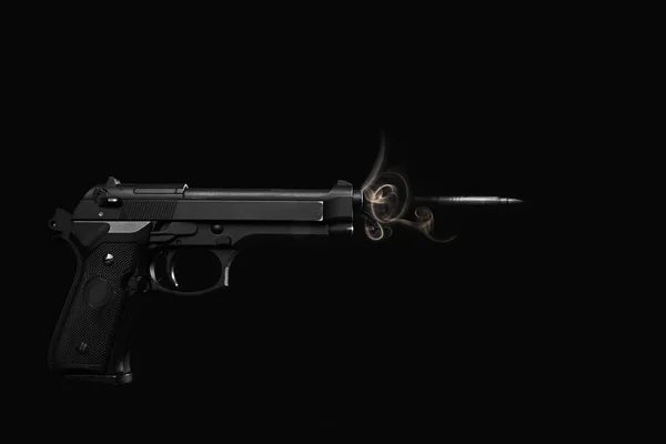 a bullet is fired from a pistol with speed effect in a studio shot on a black background. horizontal