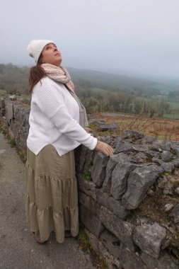 Bayan kışın gökyüzüne bakar.