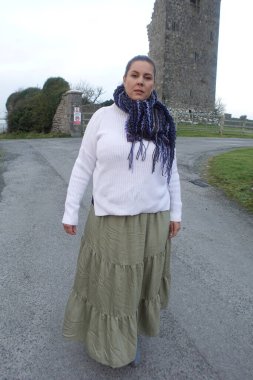 İrlanda 'nın kırsal kesimlerinde eski şatonun önünde duran kadın kışın harabe olur.