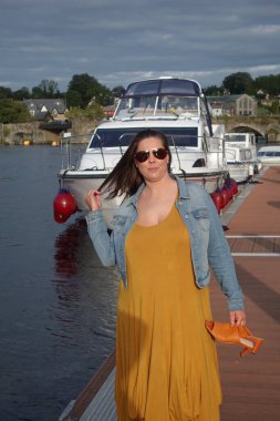 İrlanda 'nın doğusunda yer alan Clare ilçesinde büyük bir köy olan Killaloe yat limanında güzel bir bayan vakit geçirir.