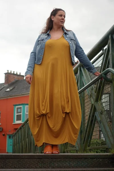 Lady standing on the bridge to enjoy the view of the village of Killaloe in Ireland