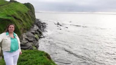 Lahinch 'te Atlantik kıyısında bir kadın duruyor.