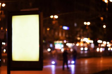 Akşamları şehirde parlayan ışık kutusu reklamı. Caddenin yanındaki ışık panosu. Logo, metin, resim, reklam, reklam için boşluk.