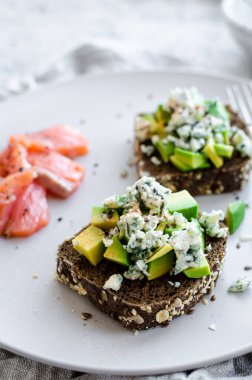 Somon balıklı sağlıklı kahvaltı ve çavdar ekmekli tost, avokado ve küflü peynir..