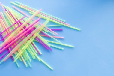 Mavi arka planda renkli plastik pipetler. Plastik pipet içmeye hayır de. Sıfır sürdürülebilir yaşam konsepti. Tekrar kullan, azalt, reddet. Üst Manzara. Boşluğu kopyala.