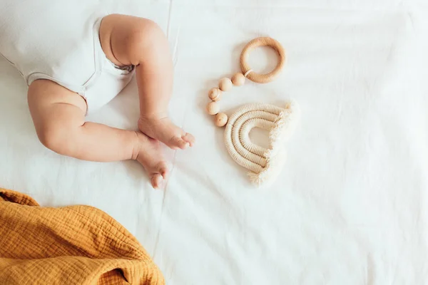 Baby Spelen Met Een Houten Speelgoed Witte Linnen Achtergrond Bovenaanzicht — Stockfoto