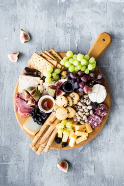 Şarküteri tahtası. Peynir tabağı: parmesan, maasdam, camembert, cheddar, gouda prosciutto, salam, meyve ve fındıklı. Lezzetli aperatifler ya da antipastalar. Üst Manzara. Boşluğu kopyala.
