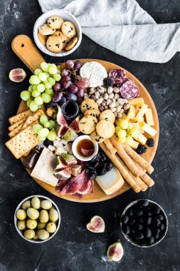 Şarküteri tahtası. Peynir tabağı: parmesan, maasdam, camembert, cheddar, gouda prosciutto, salam, meyve ve fındıklı. Lezzetli aperatifler ya da antipastalar. Üst Manzara. Boşluğu kopyala.