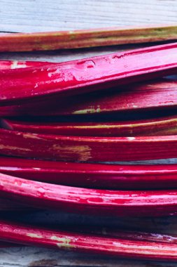 Tahta arka planda toplanmış taze organik ravent sapları. Rubarb dokusu. Üst görünüm.