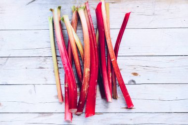 Tahta arka planda toplanmış taze organik ravent sapları. Üst görünüm.