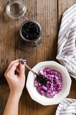 Süzme peynirli sağlıklı kahvaltı ve ahşap arka planda yabanmersini reçeli. Üst görünüm.