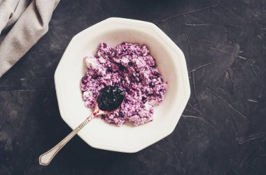 Süzme peynirli sağlıklı kahvaltı ve siyah arka planda yabanmersini reçeli. Üst görünüm.